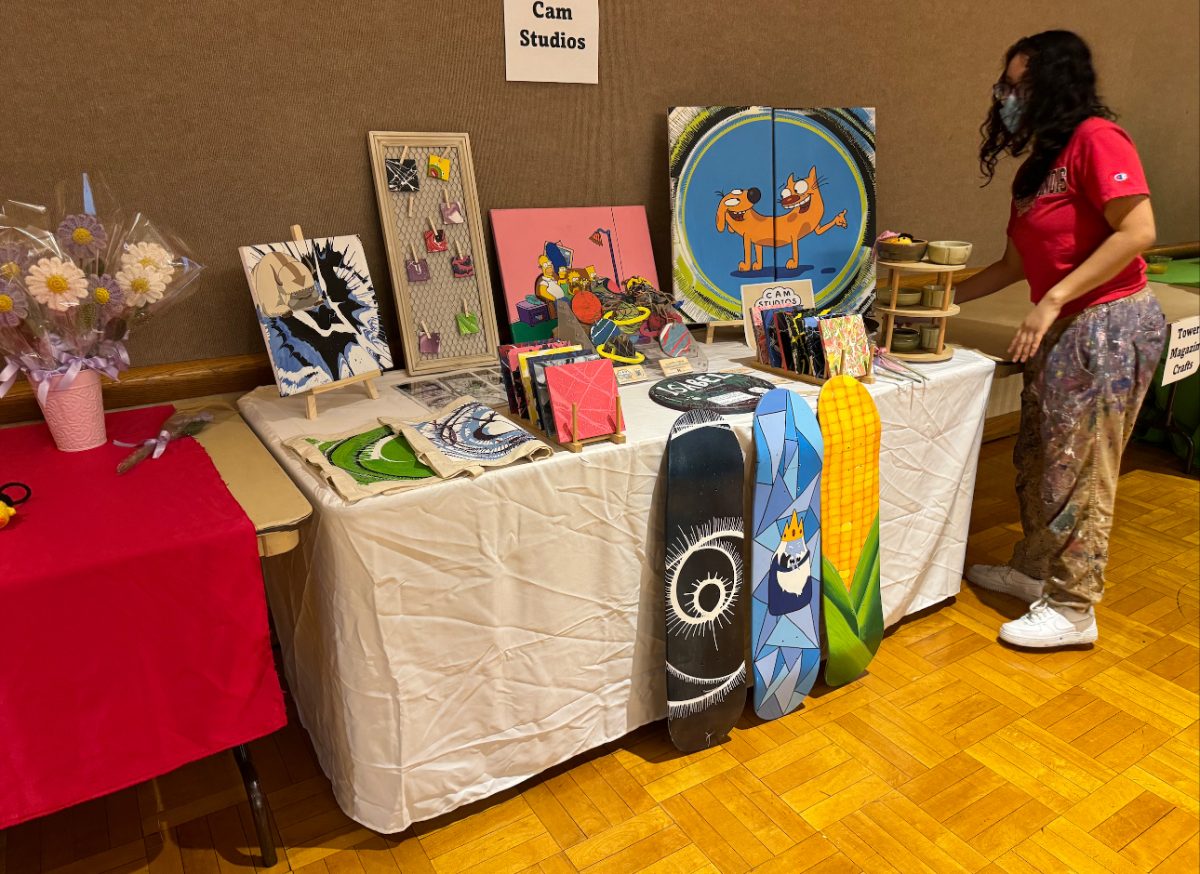Isabel Cambray, a senior illustrations major, shows off her table of vibrant artwork. The Welcome Back Brunch and Makers Market had multiple student run businesses showing off items they made to sell. (Gabby Crabtree| Northern Star)