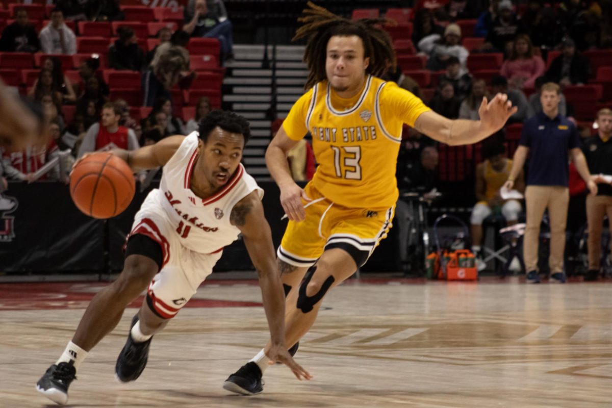 After quickly obtaining the ball, junior guard David Coit (11) rushes down court as Kent State junior guard Jalen Sullinger (13) follows quickly behind. Coit scored a total of 17 points for the Huskies during the game Tuesday. (Sean Reed | Northern Star)