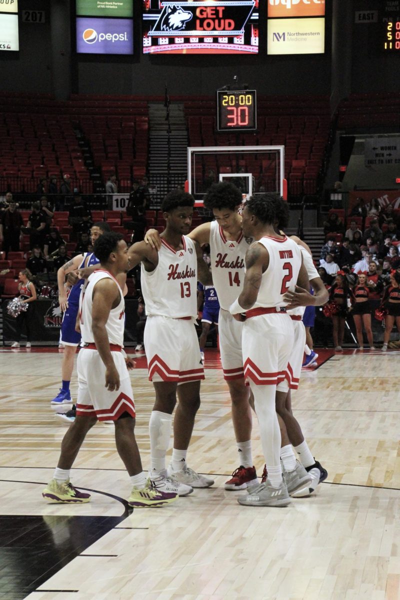 The NIU mens basketball team huddles for a pregame talk about their match against Indiana State Dec. 5. The Huskies were defeated by the University of Iowa 103-74 Friday. (Nyla Owens | Northern Star)