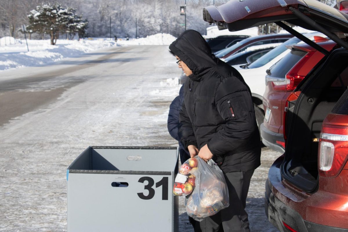 Freshman computer science major Sebastian Santellanes removes groceries from the trunk of his family’s car before placing them into a cart with other items Monday next to Stevenson Towers. Temperatures at Stevenson Towers were minus 4 degrees Monday afternoon. (Sean Reed | Northern Star)