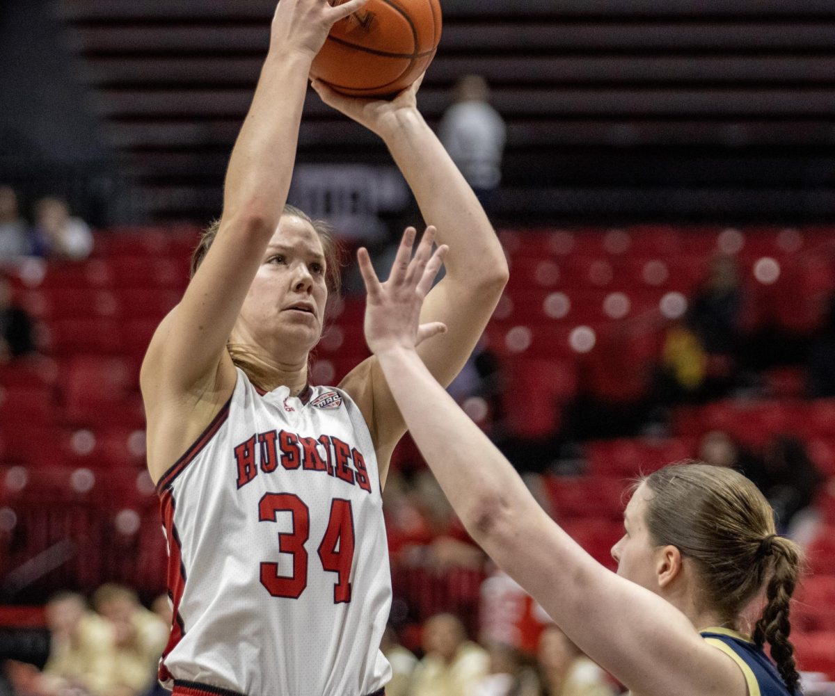 Senior forward Brooke Stonebraker (34) shoots a jump shot over an Akron University opponent. Stonebraker scored 15 points in a 72-54 loss to Bowling Green State University on Wednesday. (Tim Dodge | Northern Star)