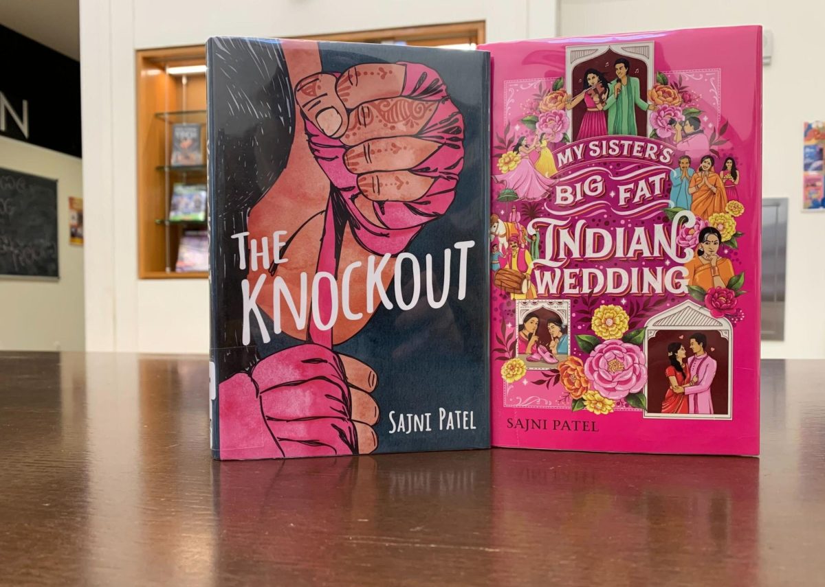 Two books by Sajni Patel, “The Knockout” and “My Sister’s Big Fat Indian Wedding,” sit upright on a desk. Patel’s newest book, “A Drop of Venom,” released last week. (Nick Glover | Northern Star)