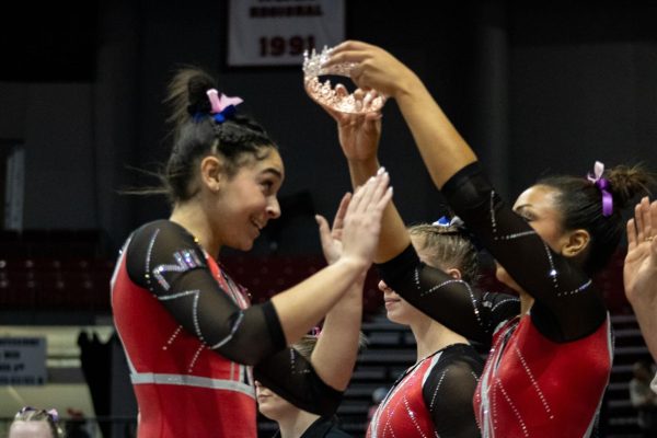 NIU freshman gymnast Isabella Ross places a crown upon freshman Dawsyn Sallee’s head during the Huskies’ home quad-meet Sunday at the Convocation Center. Sallee received MAC Specialist of the Week honors Tuesday after posting NIU’s highest scores on vault and beam at the meet. (Sean Reed | Northern Star)