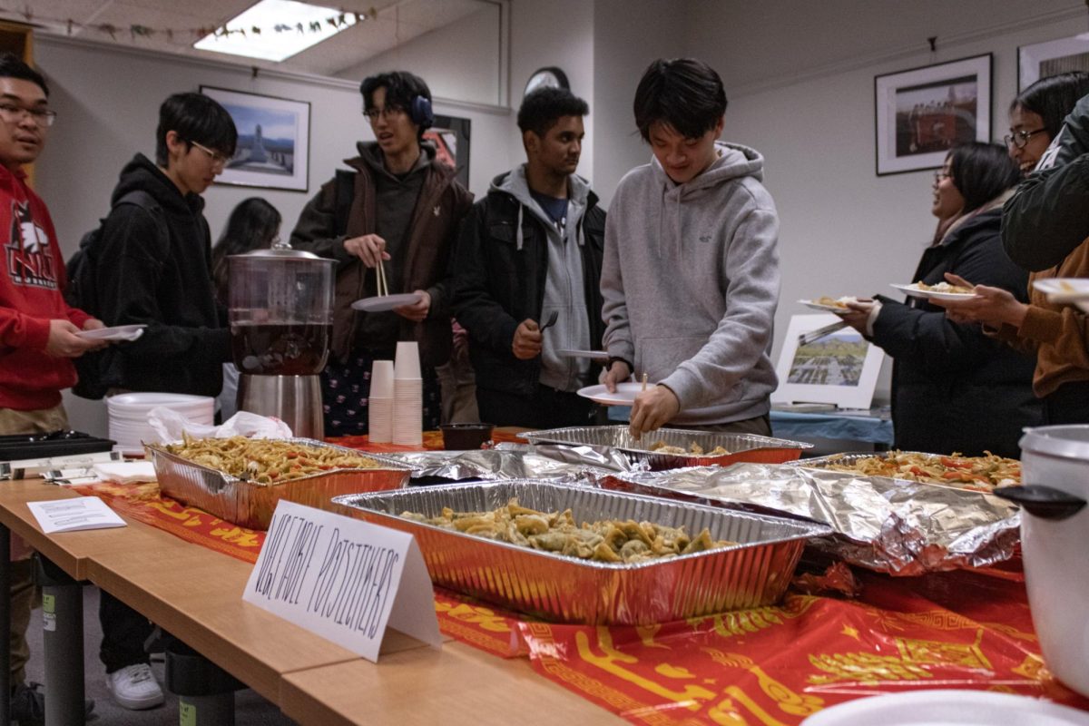 Students+and+staff+gather+around+a+table+in+the+conference+room+at+the+AARC%2C+filling+plates+with+lo+mein%2C+sticky+rice+and+potstickers.+Food+was+available+to+all+attendees+of+the+event+Tuesday%2C+including+veggie+potstickers+for+attendees+who+don%E2%80%99t+eat+pork.+%28Sean+Reed+%7C+Northern+Star%29