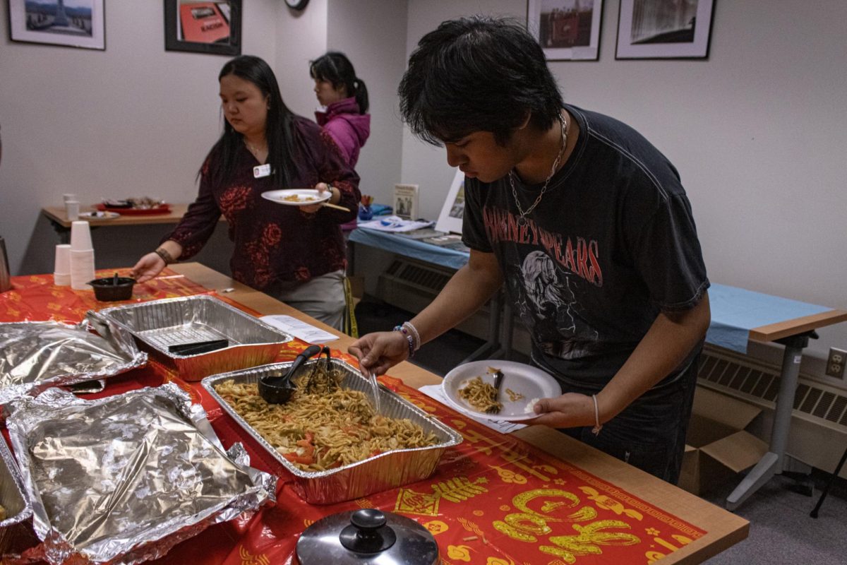 Virak Khoeun, a sophomore media studies major, returns to the spread of food and adds some additional lo mein to his plate. Other events the AARC will host in celebration of the Lunar New Year this week include time for students to pick up a red envelope from 9 a.m. to 3:30 p.m. Wednesday and a luncheon from 11:30 a.m. to 1:30 p.m. Thursday at Neptune Dining Hall. (Sean Reed | Northern Star)