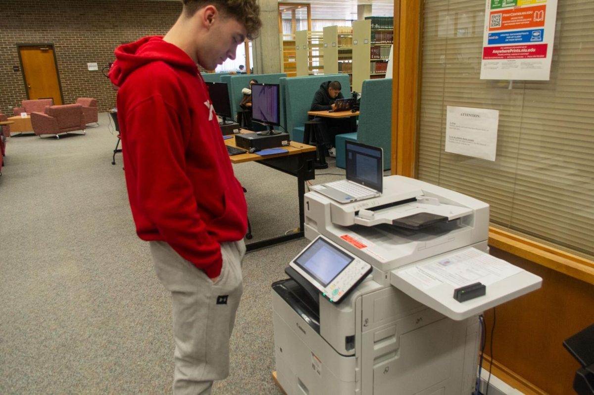 Tyler Camling, sophomore finance major, uses a printer on the first floor of Founders Memorial Library. Printing on campus costs students five cents per page for black and white and 12 cents for color. (Sam Dion | Northern Star)