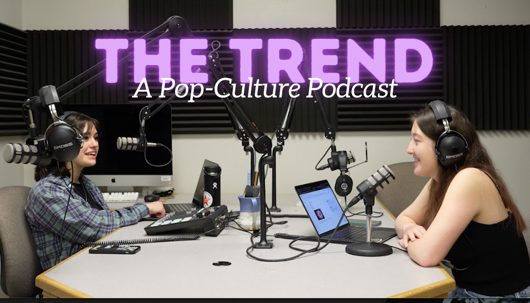 Brynn Krug (left) and Sarah Rose sit at a podcast set up and converse. This week’s episode of “The Trend” covers social media phenomena from the week of Feb. 12. (Brynn Krug | Northern Star)