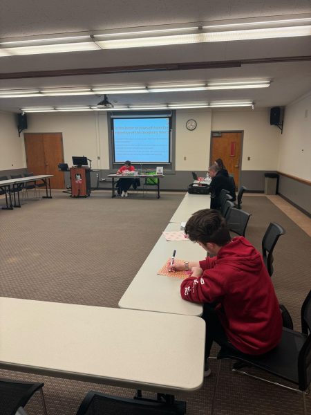 Students sit at a table and write on colorful sheets of paper. Mindfulness and You is held from 5 p.m. to 6 p.m. every Wednesday in the HSC Illinois Room for students to feel more motivated and calm. (Hannah Soukup | Northern Star)