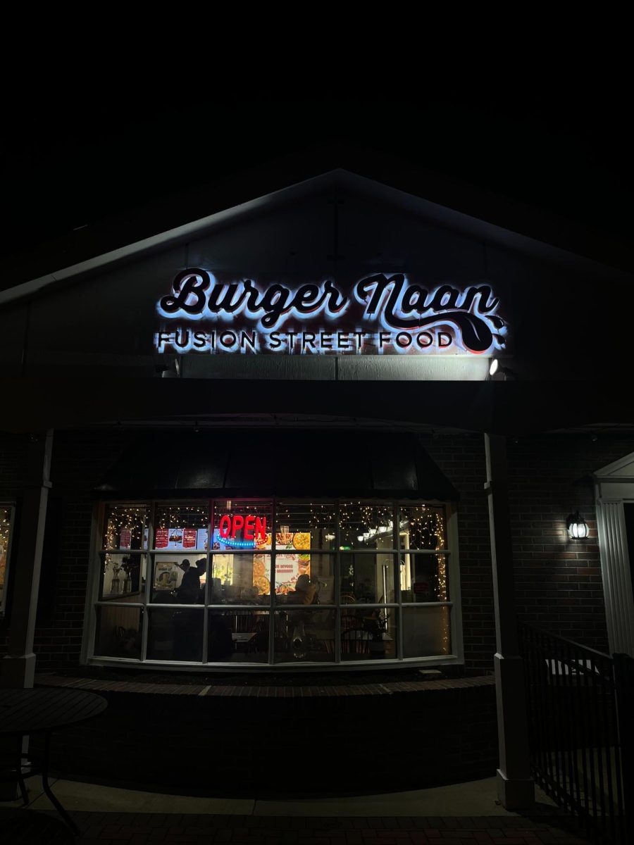 The outside of Burger Naan depicts a light-up open sign visible through the restaurants windows. Burger Naan is a family owned Indian restaurant located in downtown DeKalb. (Sofia Didenko | Northern Star)