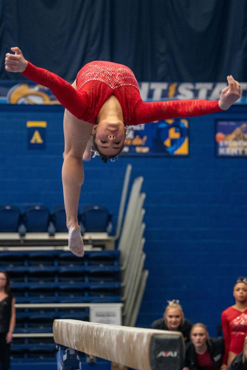 NIU gymnastics senior Alyssa Al-Ashari executes a back handspring on the balance beam during the final rotation of Sunday’s MAC dual meet against Kent State University in the Memorial Athletic and Convocation Center in Kent, Ohio. Al-Ashari matched her personal bests on bars and beam at the meet, scoring 9.925 on both events. (Candence Pierce | Kent Stater)