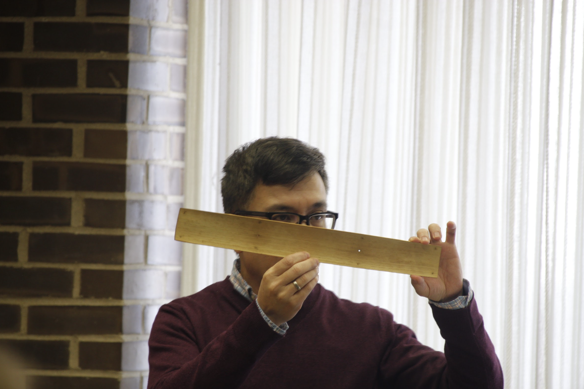 Professor Hao Phan holds up a palm leaf manuscript. Palm leaf manuscripts were first created in the 5th century, BC. (Katie Follmer | Northern Star)