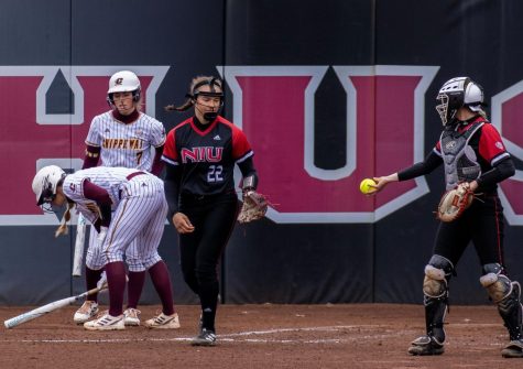 Then NIU freshman pitcher and utility player Danielle Stewart (22) reaches for the ball as then junior catcher Ellis Erickson (23) passes it at home plate during NIU Softballs home game against Central Michigan University March 31, 2023. Stewart struck out eight batters in a complete game win over University of Alabama at Birmingham Saturday. (Northern Star File Photo)