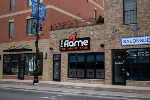 The Flame, 209 East Lincoln Highway, stands next to two hair salons in downtown DeKalb. The Flame opened its doors Jan. 15 and has extended to carry-outs during open hours, 11:30 a.m. to 8:30 p.m. Sunday through Thursday and closes an hour later Friday and Saturday. (Totus Tuus Keely | Northern Star)