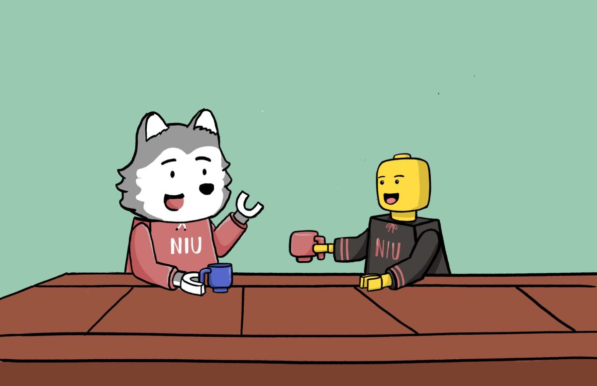 Lego depictions of Victor E. Huskie and a person in NIU merch sip drinks while sitting at a wooden table. International Lego Day was celebrated Jan. 28. (Isabel Cambray | Northern Star) 