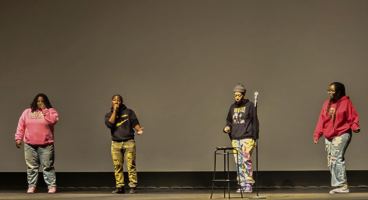The crew of Four Poets, One Mic stands on stage during their Feb. 22 performance. Four Poets, One Mic is an NIU group where people write and perform poetry. (Zahra Yousif | Northern Star)