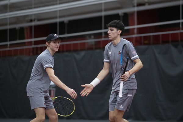 Freshman Sam Klein (left) and sophomore Iker Gaztambide Arrastia (right) reach for a handshake at the Nelson Tennis Center at Chick Evans Field House. Gaztambide Arrastia won his doubles match with sophomore Christopher Norlin as NIU defeated Ball State University 5-2. (Scott Walstrom | NIU Athletics)