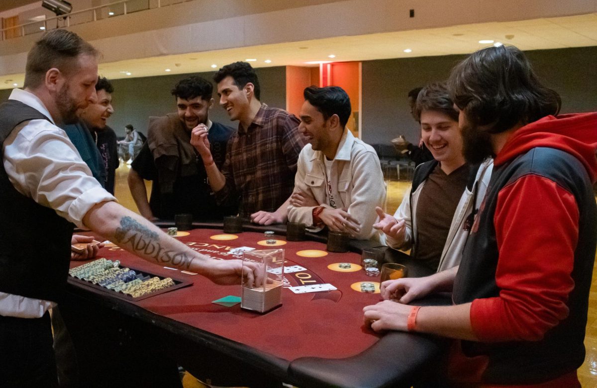 Students laugh after two of the eight casino chips are left after the previous hand at dealer Ryan McBride’s table. Spirits were high in the ballroom as students bet or bankrupt the casino chips that lacked a value. (Totus Tuus Keely | Northern Star)