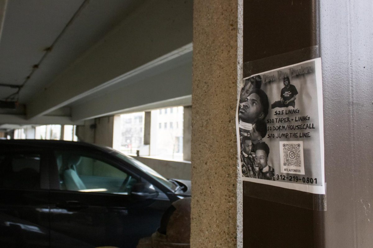 A flyer hangs on the wall of the NIU Parking Deck. Some NIU students do hair to make extra money while in school. (Sean Reed | Northern Star)