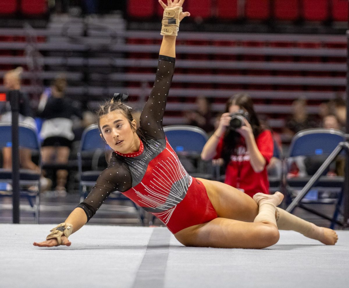 Junior gymnast Isabella Sissi swings her arms out as she poses during her floor routine. Sissi returned to NIUs lineup Sunday after missing the Huskies home finale on March 10. (Tim Dodge | Northern Star)