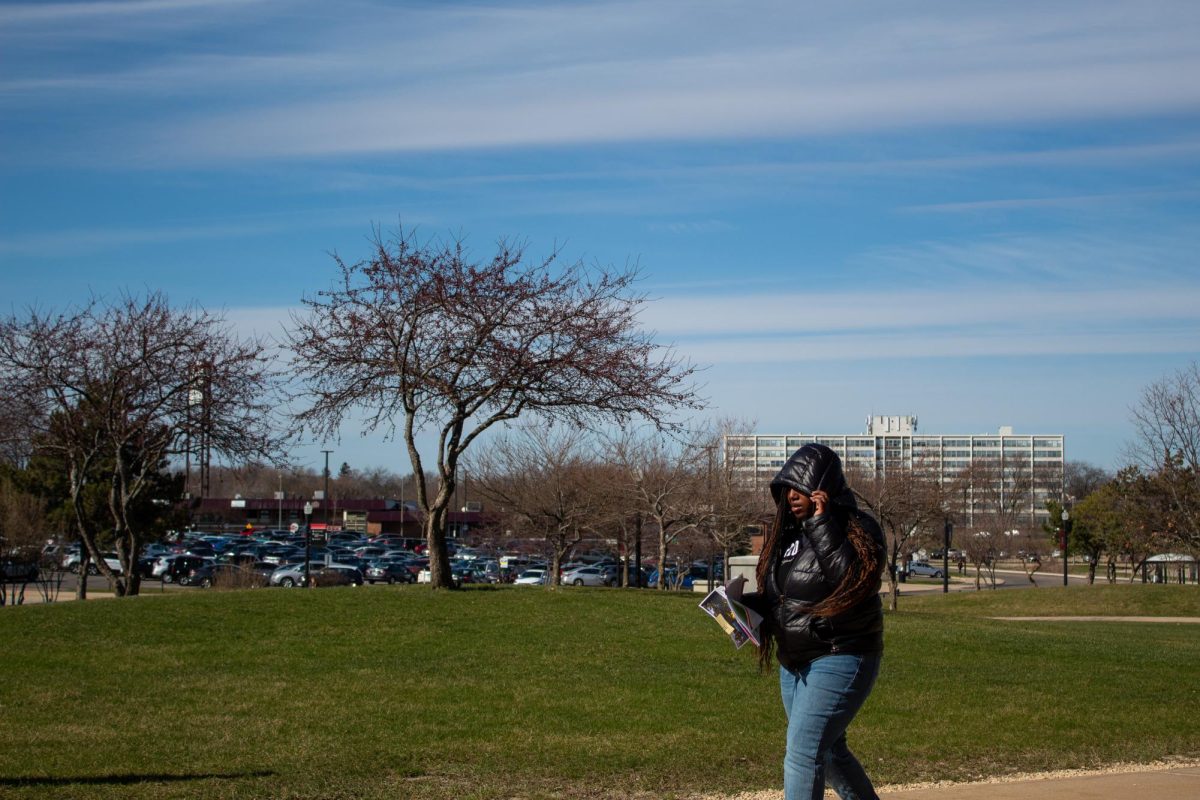 Quick wind gusts and cold temperatures cause first-year health sciences major Janiyah Pollard to bundle up and block the wind. Tuesday saw a clear sky occasionally disrupted with the wispy cirrus clouds following the easterly winds. (Totus Tuus Keely | Northern Star)