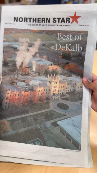A hand holds a 2024 Best of DeKalb print edition over a table. Pick up your own copy in the news stands around campus. (Anna Scanlan | Northern Star)
