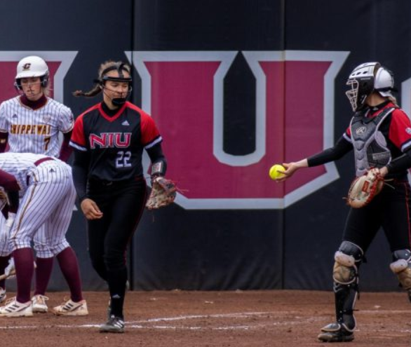 Then NIU freshman pitcher and utility player Danielle Stewart (22) reaches for the ball as then junior catcher Ellis Erickson (23) passes it at home plate during NIU Softballs home game against Central Michigan University March 31, 2023. The Huskies were swept by the University of Akron Zips, losing 7-6 in the final game of the series Sunday. (Northern Star File Photo)