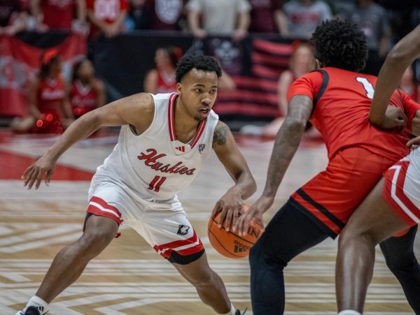 Junior guard David Coit surveys the court with Ball State junior guard Jaylin Anderson guarding him in an NIU mens basketball game on Feb. 20. Coit and senior guard Keshawn Williams both entered the transfer portal on Monday. (Northern Star File Photo)