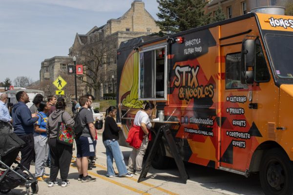  Students stand in line at Stix and Noodles during Food Truck Wednesday in MLK Commons. Stix and Noodles is a Filipino food truck based out of Lake in the Hills, which serves combo meals including an entree, rice and side. (Sean Reed | Northern Star)

