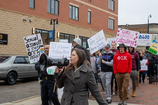 Kelsey Gettle, legal program manager for Safe Passage, leads the crowd through their final chants before returning to the Egyptian Theatre. The crowd then returned their signs and took their seats for the survivor speak out, which took place until roughly 7:30 p.m. (Sean Reed | Northern Star)