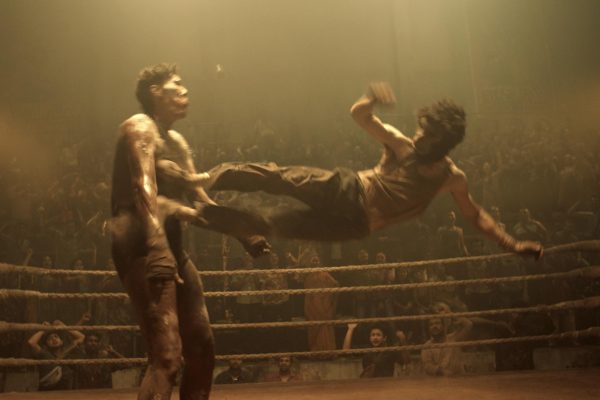 A man in a monkey mask kicks another man standing in a fighting ring in a scene from Monkey Man. Monkey Man, Dev Patels directorial debut, released Friday. (Universal Pictures via AP)