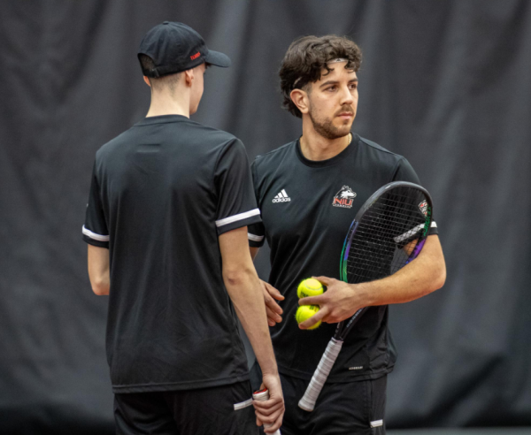 Freshman Saul Berdullas (left) and senior Armin Koschtojan (right) talk strategy during a doubles match on March 2. NIU mens tennis was eliminated from the MAC Championship on Saturday with a 4-0 loss to the University of Toledo. (Northern Star File Photo)