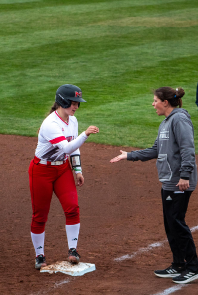 Junior middle infielder/outfielder Avery Carnahan high fives NIU assistant coach Alaynie Woollard on March 27 at Mary M. Bell Field. Carnahan hit a 3-run single against the University at Buffalo as NIU softball split Saturdays doubleheader. (Northern Star File Photo)