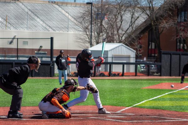 Senior outfielder/catcher Collin Summerhill drives a baseball off his bat against Bowling Green State University on Saturday. The Huskies were swept by the Falcons in a doubleheader Saturday. (Totus Tuus Keely | Northern Star)