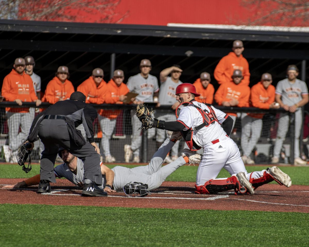 Senior catcher Colin Summerhill (8) tags Bowling Green freshman catcher Garrett Wright (3) for the out at home plate during the sixth inning of an NIU baseball game on April 6. Summerhill hit his 13th home run of the 2024 season against the University of Illinois on Saturday. (Tim Dodge | Northern Star)