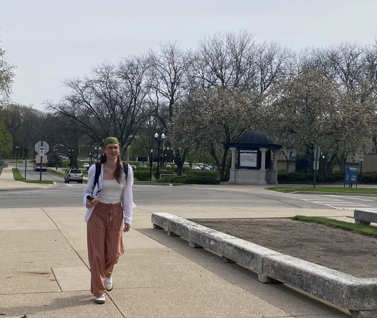 Sarah Marsh, a sophomore communications major, walks near the East Lagoon. With the chaotic weather of spring, students should dress in layers to fit the changing temperatures. (Brynn Krug | Northern Star)