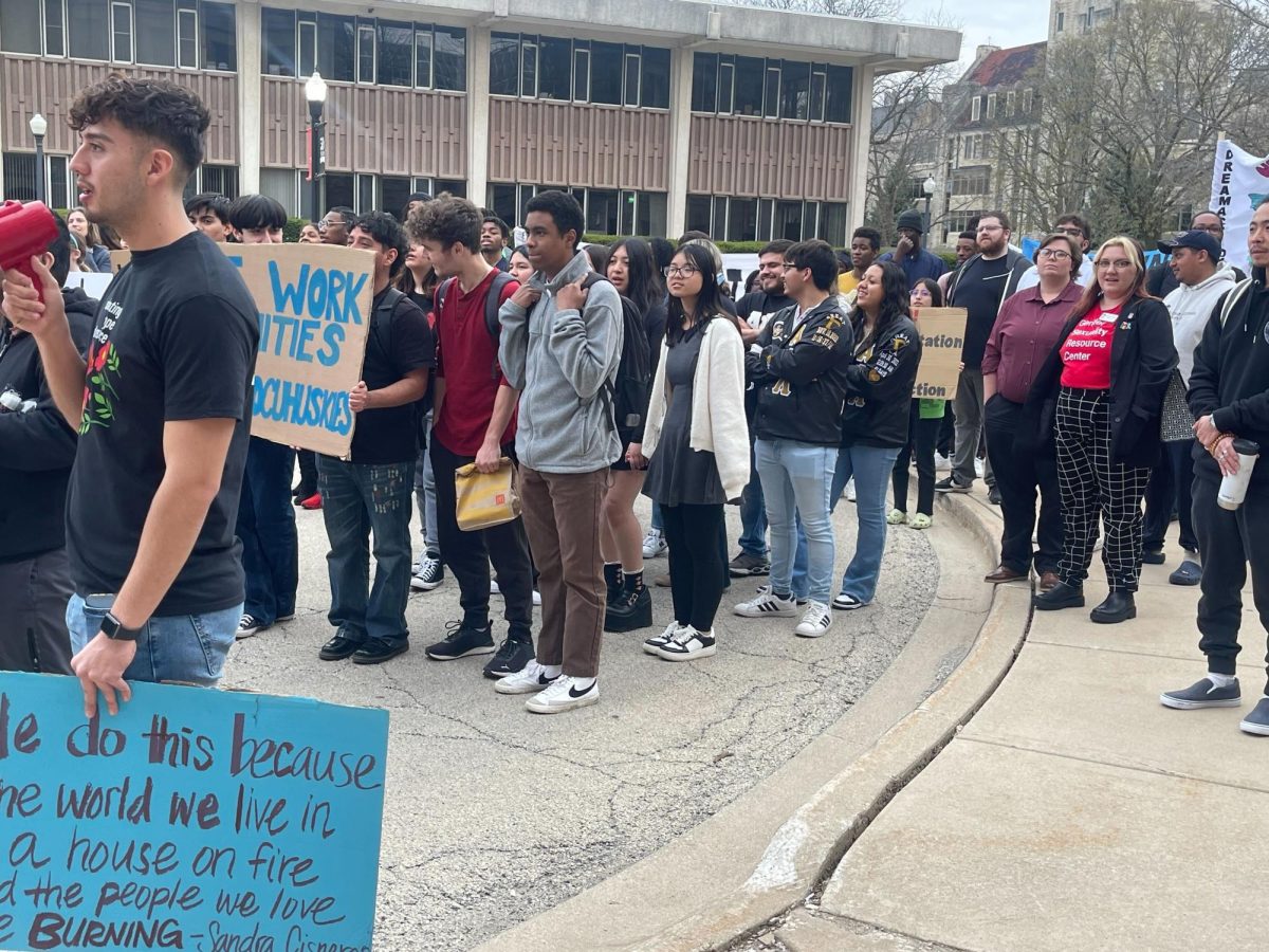 A group of students stand outside Altgeld Hall holding signs during the Coming Out of the Shadows event Wednesday. The Coming Out of the Shadows event included speeches, a march to President Lisa Freemans office, a musical performance by Monotone and free tacos. (Emily Beebe | Northern Star)
