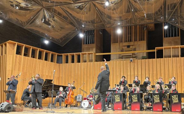 Reggie Thomas cuts off the NIU Jazz Orchestra on a song where Sean Jones (left) and Wycliffe Gordon are featured. Thursday’s concert was Thomas’ final concert leading the orchestra. (Nick Glover | Northern Star)