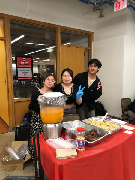 Senior business administration major Say Paw (from left), junior nursing major Melita Inthabandith and sophomore communications major Virak Khoeun stand at a table selling food. Homemade food prepared by students was one of the primary items sold during the Asian Night Market. (Jenny Javkhlantugs | Northern Star)