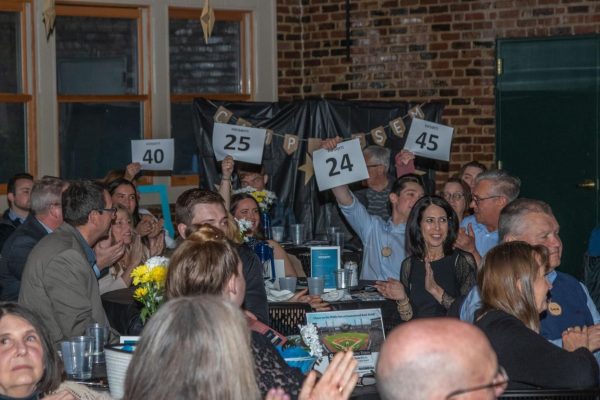 People clap and cheer while holding up papers at the 2023 Kesem Make the Magic Gala last spring. The sixth annual gala will happen at 5:30 p.m. on Saturday in the Hopkins Park Shelter. (Courtesy of Darby McGowan)