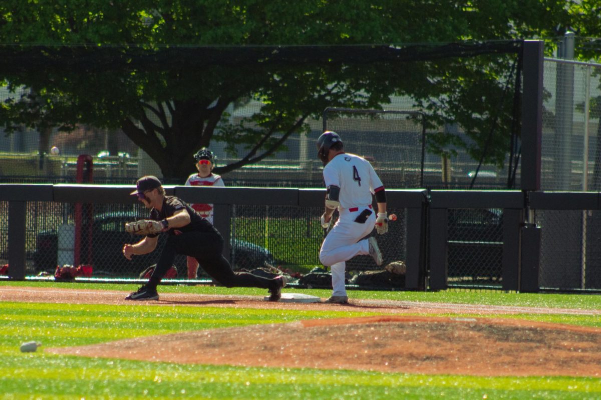 Freshman catcher Cooper Cohn (4) beats a throw to first base on May 3 at Ralph McKinzie Field at Walt and Janice Owens Park. NIU baseball lost the series finale against Ball State University by a score of 13-10 on Sunday. (Totus Tuus Keely | Northern Star)