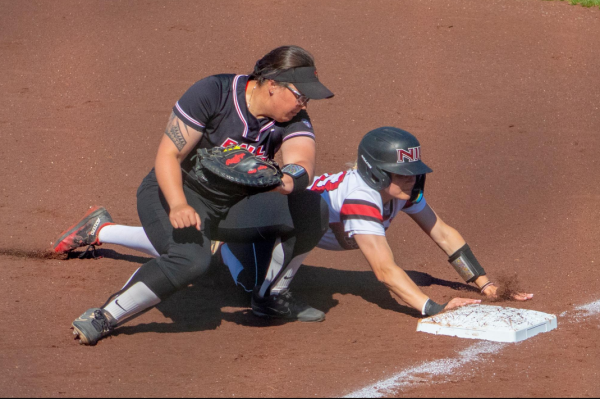 Senior catcher/outfielder Ellis Erickson dives back to first base on Tuesday at Mary M. Bell Field. NIU softball dropped all three games of its regular season finale against Miami University on Saturday. (Northern Star File Photo)