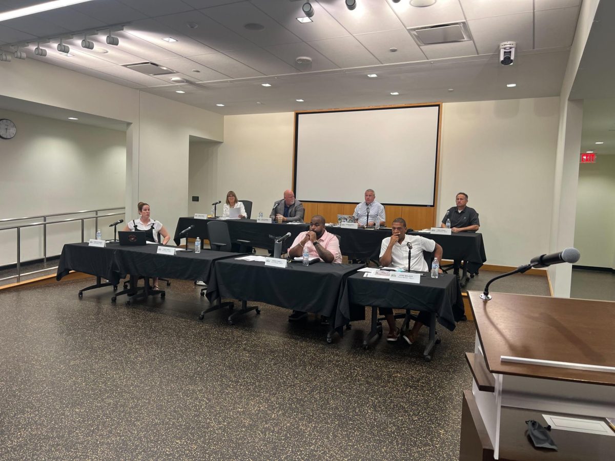 Members of the DeKalb City Council sit at a table during Mondays City Council meeting. The DeKalb City Council passed an ordinance decreasing the salary of the city clerk from $8,000 to $0. (Devin Oommen | Northern Star)