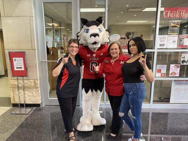 (From left) Margee Myles, director of the LRS undergraduate student success center, Victor E. Huskie, Joan Phillips-Hernandez and Olivia Collier, a senior business management major pose for a photo while making the huskie sign. Phillips-Hernandez was recently hired as the new dean of the College of Business in July. (Courtesy of Rachel Schmit)