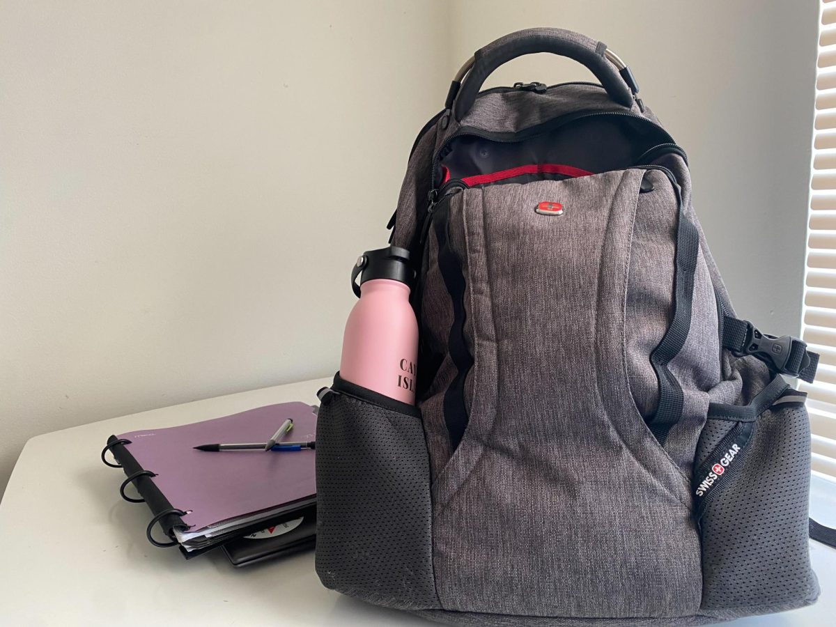 A photo illustration shows a backpack and notebook sitting on a table. Make sure your backpack has everything you need to be prepared for class. (Brynn Krug | Northern Star)