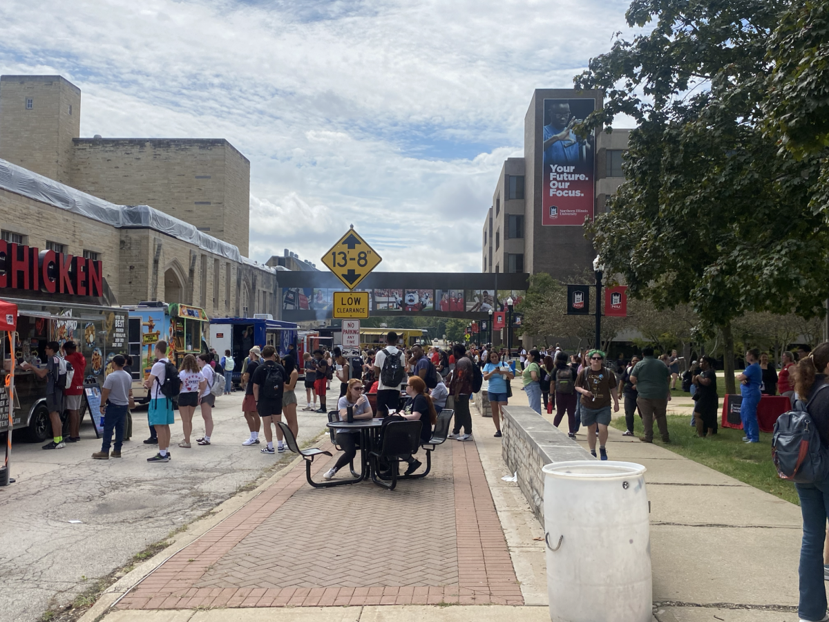 A group of students gather at the kickoff of Food Truck Wednesdays hosted at the MLK Commons on Wednesday. Each Wednesday there will be up to 12 food trucks for students to go to. (Zahra Yousif | Northern Star)