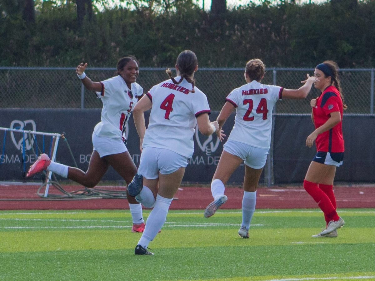 Sophomore forward Tyra King (5) celebrates with her NIU team members after scoring the first goal of the game. King led the team with two goals as the Huskies defeated the University of Southern Indiana 6-1 on Thursday. (Totus Tuus Keely | Northern Star)