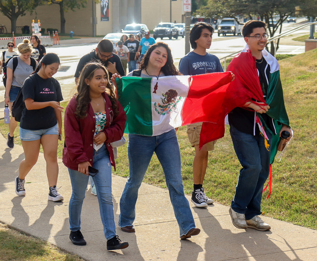  Daniela Olivares, a senior sports management major, holds a Mexican flag while walking with a group of students during the Latino Heritage Parade. There will be many Latino Heritage Month events including a Latino Dinner on Oct. 2 at Patterson Dining.  (Marco Alvarez | Northern Star)