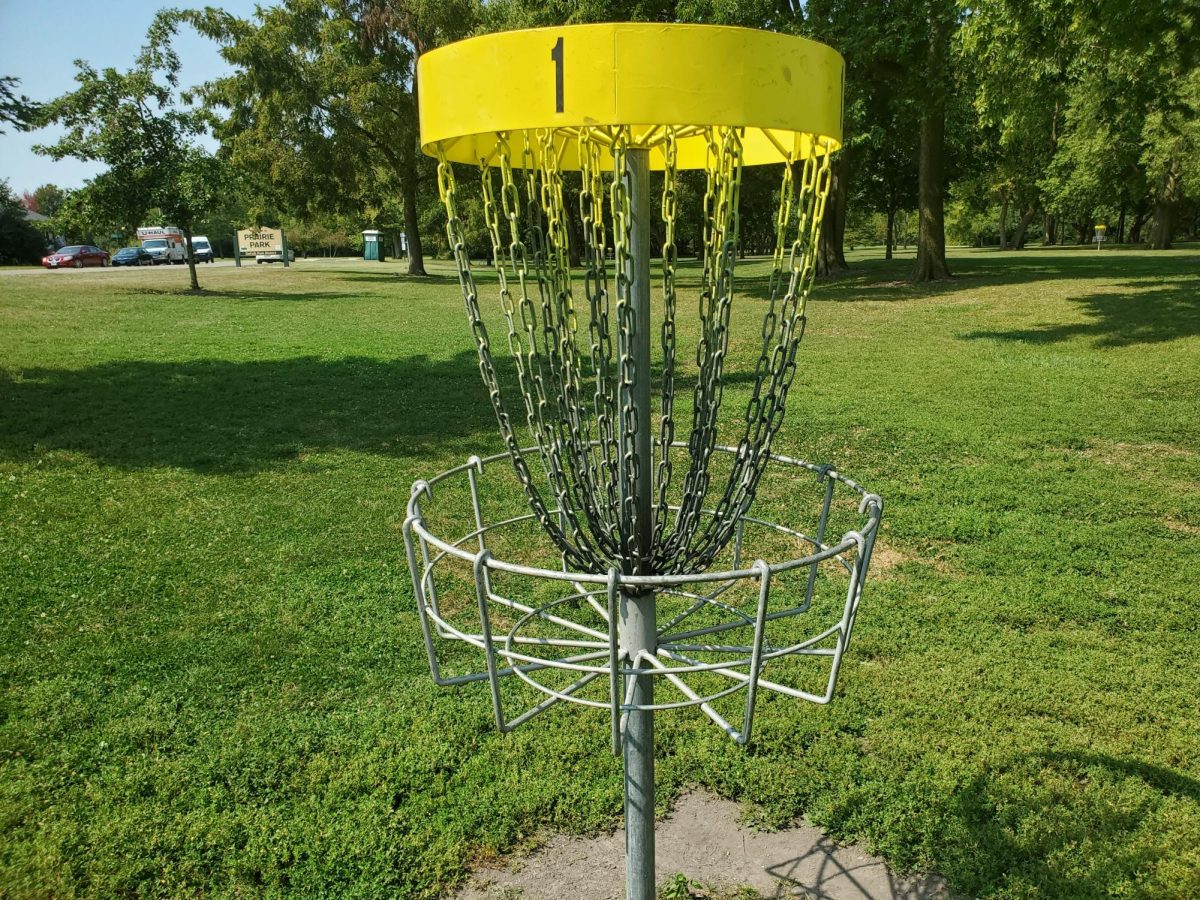  A disc golf basket goal sits Wednesday afternoon at Prairie Park in DeKalb. The first hole of the disc golf course is a Par 3 that is 242 yards. (Jonathan Shelby | Northern Star)   