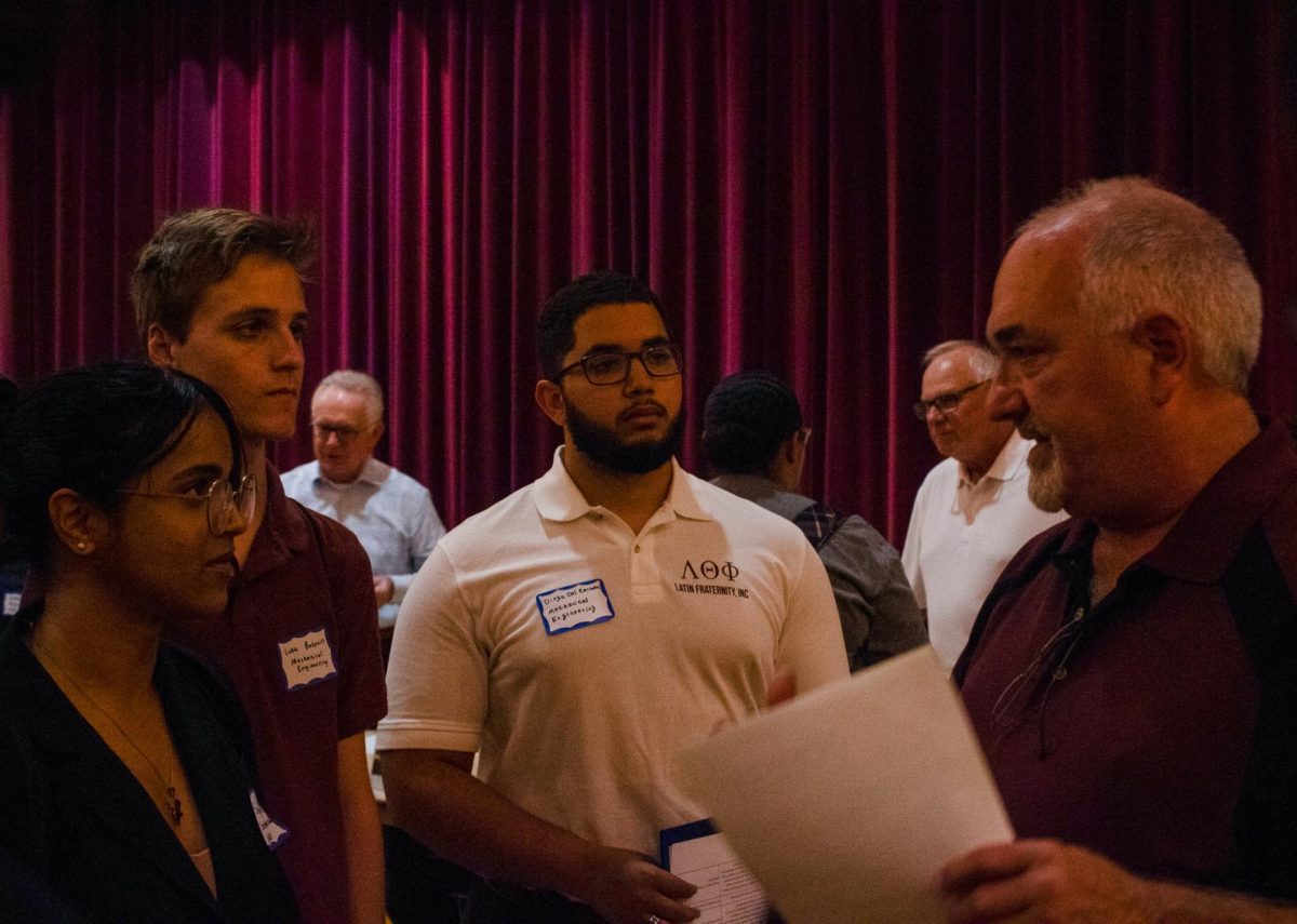 A group of students gather to talk to an employer at the STEM/IT Fair. The fair provides an opportunity for students, alum and community members to connect with employers for potential recruitment. (Ethan Rodriguez | Northern Star)