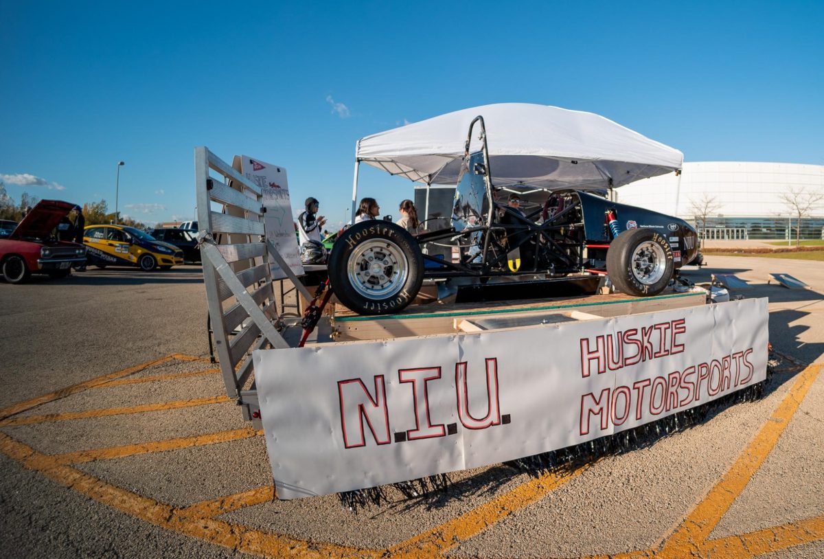 A sign that reads N.I.U. Huskie Motorsports sits attached to a trailer in the parking lot nearby the NIU Convocation Center. The NIU Huskie Motorsports club will host a car show from 9 a.m. to 3 p.m. on Sept. 22. (Courtesy of NIU Huskie Motorsports)